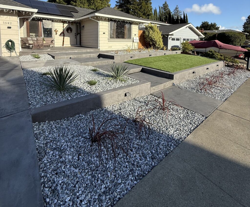 Finished front yard in Fairfield CA with concrete retaining walls, steps and a front patio in black color hardener