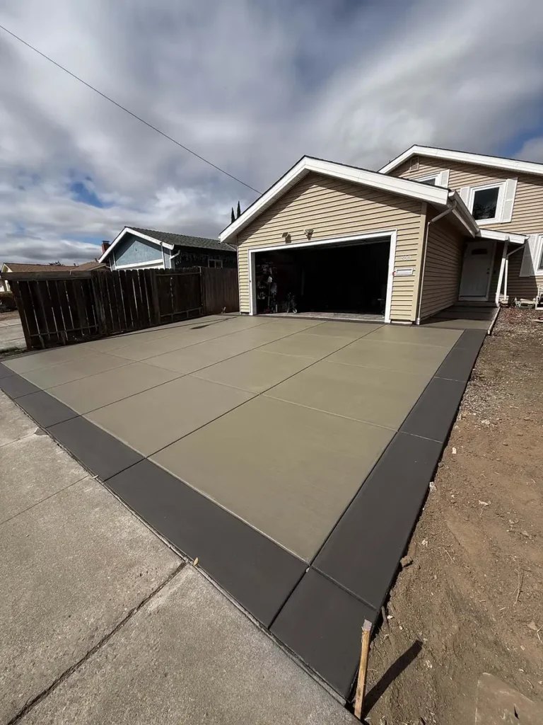 Newly poured concrete driveway leading to a two-car garage