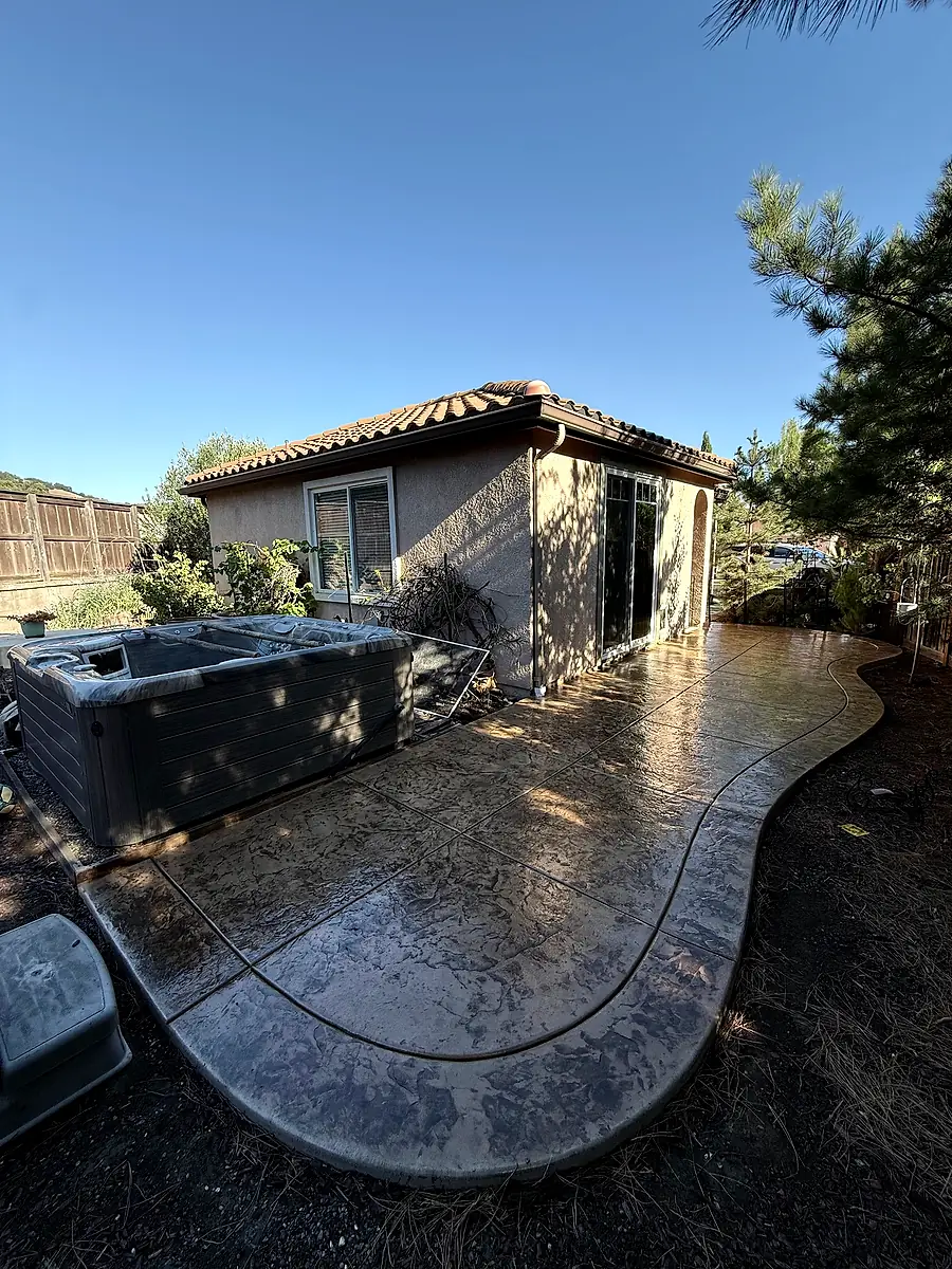 Curved stamped concrete patio in a backyard