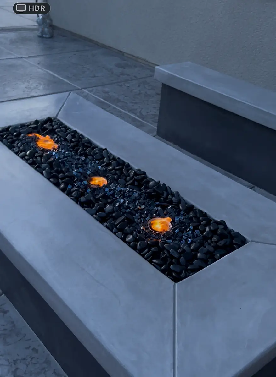 Close-up of a modern concrete fire pit with fire glass