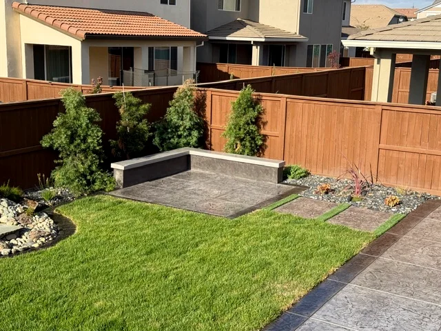 Finished Spring Lake backyard with stamped concrete seating area, stepping pads and new lawn