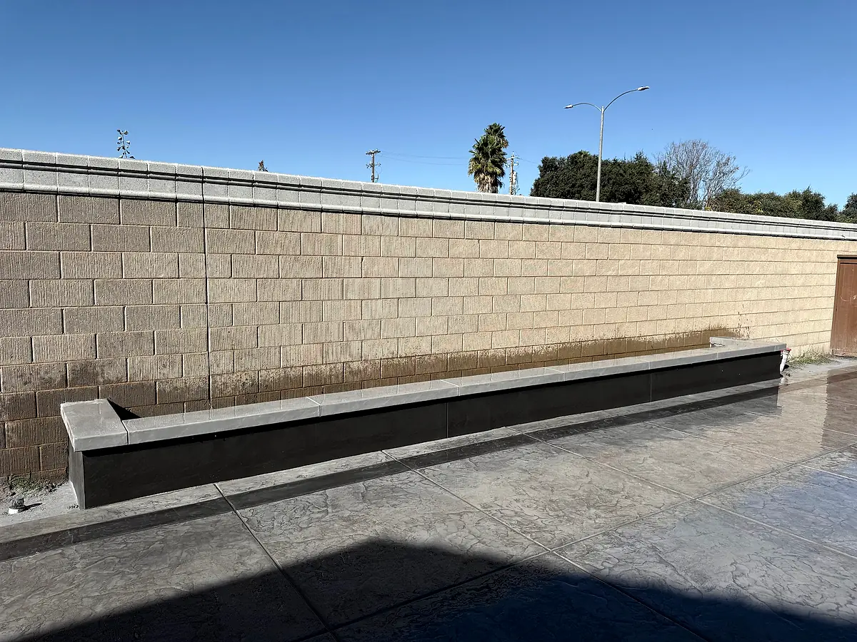 Built-in concrete bench along the back wall of a stamped patio in Woodland