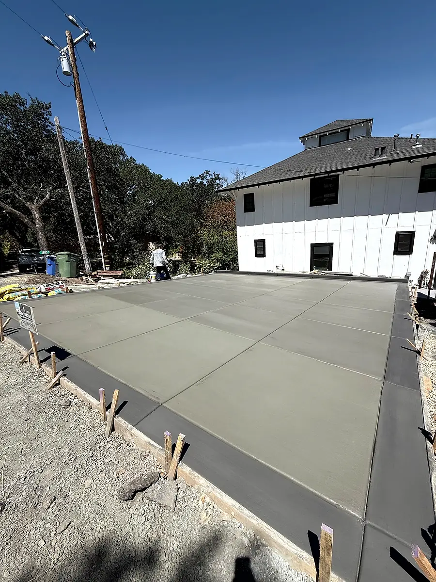 Fresh broom-finish concrete slab with a smooth dark border at a Yountville farmhouse